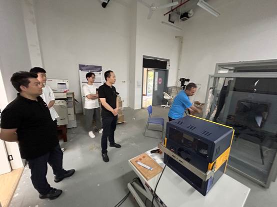 A group of men standing in a roomDescription automatically generated